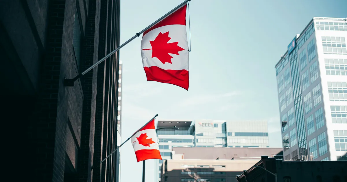 Canadian flags on a downtown office building — money services in Canada answer to federal and provincial regulators