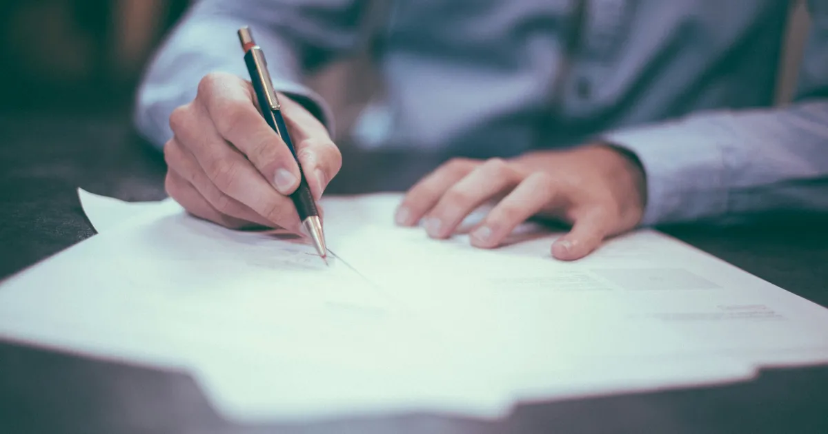 A founder signing MSB registration paperwork — FINTRAC registers reporting entities under the PCMLTFA
